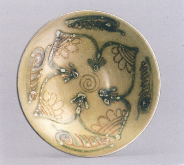图6 长沙窑青釉褐绿彩花卉纹碗。上海青龙镇遗址出土，上海博物馆藏。