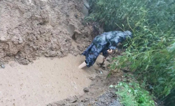 鹤壁辛村遗址考古工作人员雨中排水。（河南省文物局供图）
