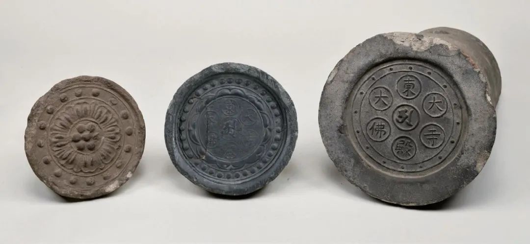 左一：复瓣莲花纹瓦当 左二：12-13世纪的梵字“阿”及“东大寺大佛殿”铭瓦当 左三：1688-1704年的梵字“阿”及“东大寺大佛殿”铭瓦当